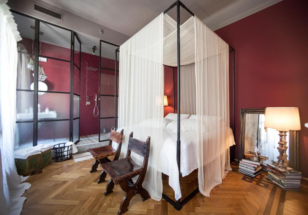 特雷维索Leconvertite的卧室配有白色大床和玻璃墙