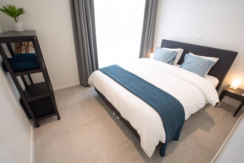 扎芬特姆Studio Brussels - EU-District的一间卧室配有一张带白色和蓝色枕头的大床