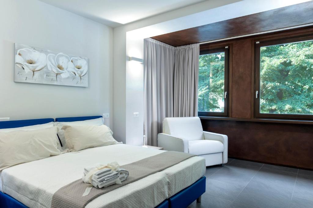 维罗纳StraVagante Hostel & Rooms的卧室配有床、椅子和窗户。