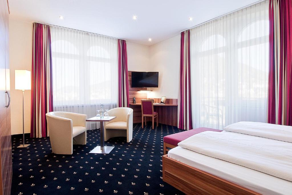 海德堡全景酒店的酒店客房带两张床和一张桌子以及椅子。