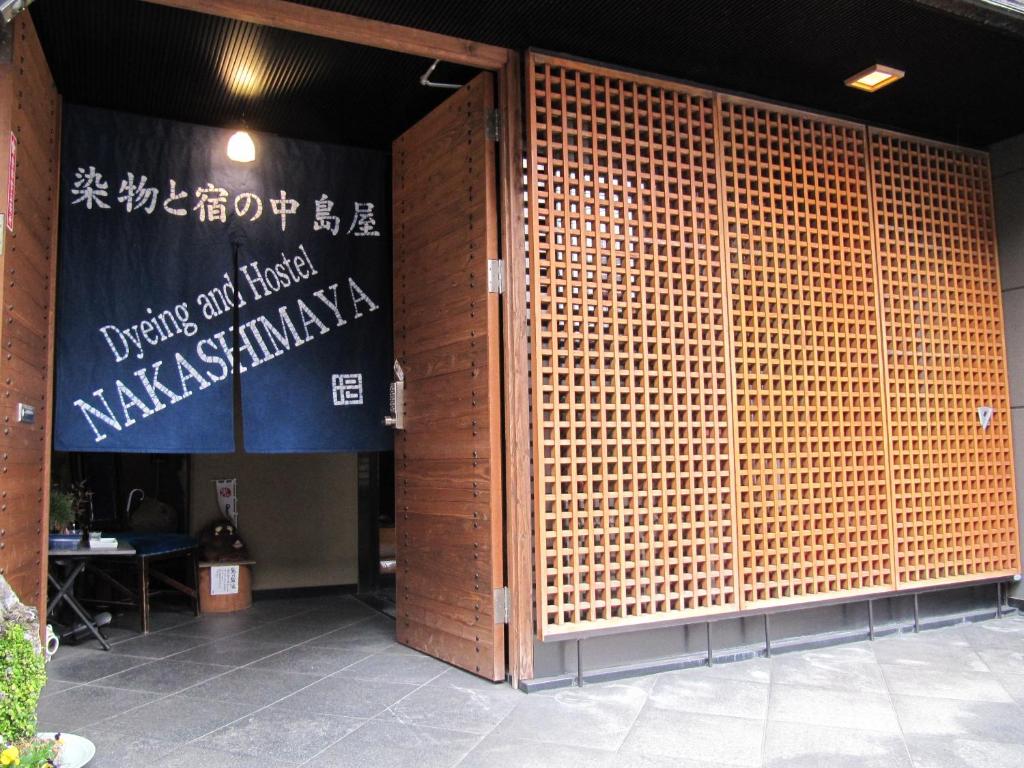 熊本中岛家族旅馆 - 仅限女性的一座带大型竹墙的建筑的入口