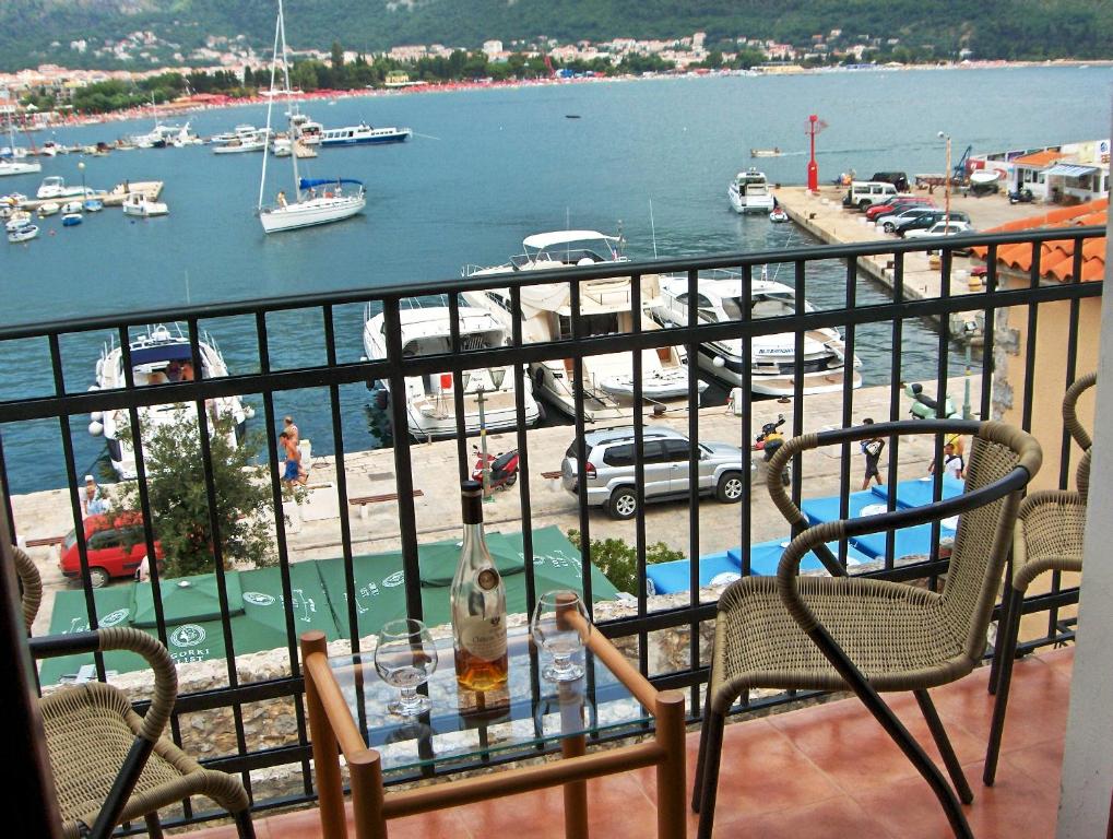 布德瓦阿勒克斯旧城公寓酒店的阳台配有桌椅,享有海港的景致。