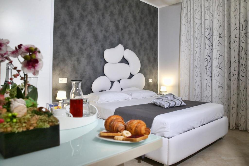 庞贝B&B Pompei Olympus的一间房间,配有一张床和一张桌子,上面有一盘面包