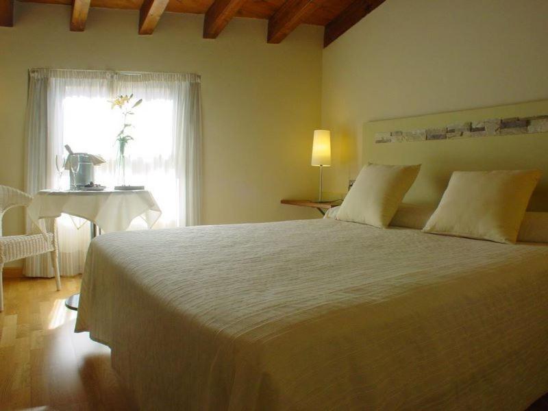 特鲁希略埃尔米拉多德拉斯蒙加斯酒店的一间卧室配有一张床、一张桌子和一个窗户。