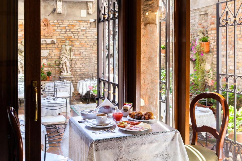 威尼斯阿尔蓬特默西尼果酒店的阳台上的餐桌上放着一盘食物