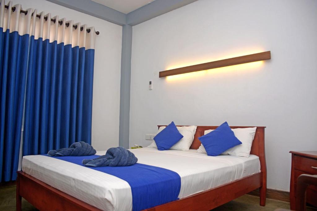 卡图纳耶克迪隆旅馆的一间卧室配有蓝色窗帘的床