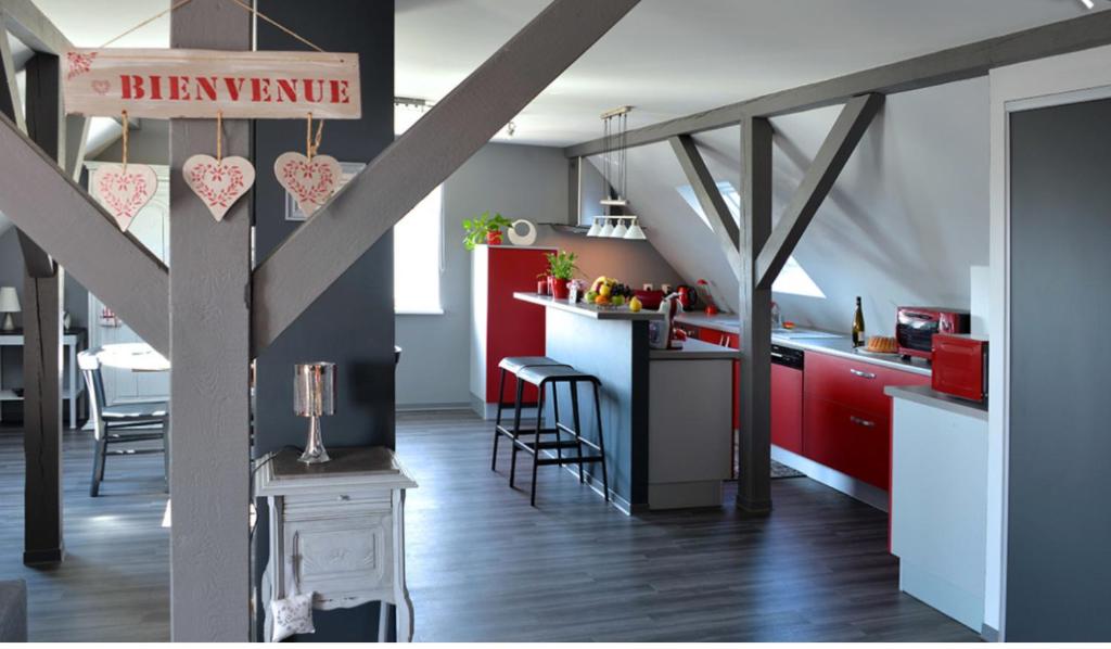 埃圭斯海姆Fleur de Vigne的厨房配有红色橱柜和桌椅