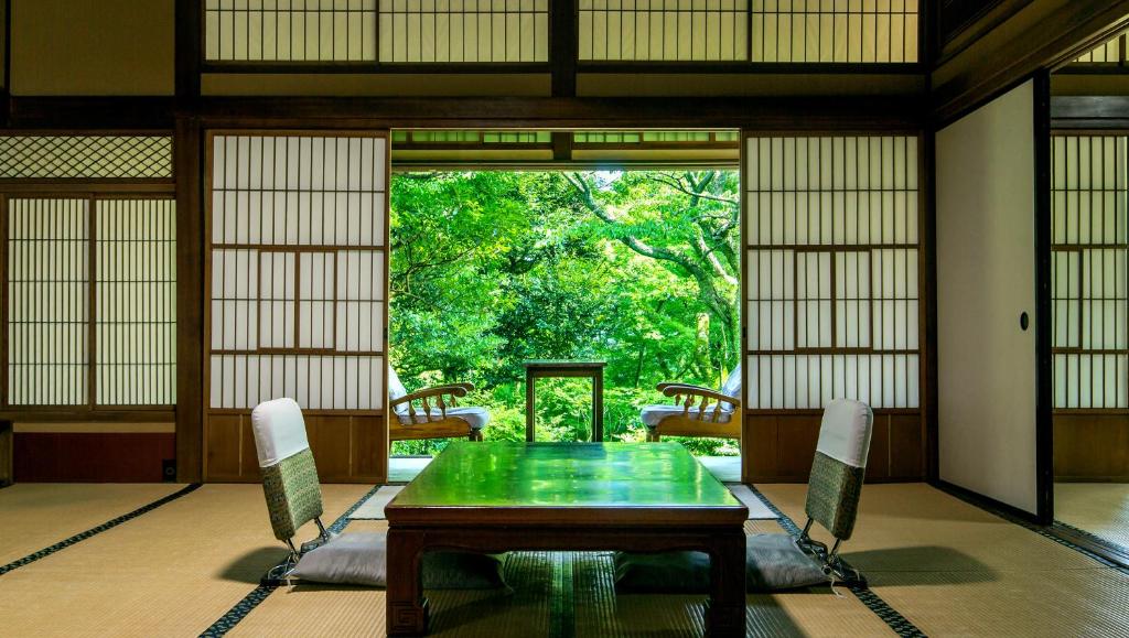 箱根强罗环翠楼的一间带绿色桌椅的用餐室