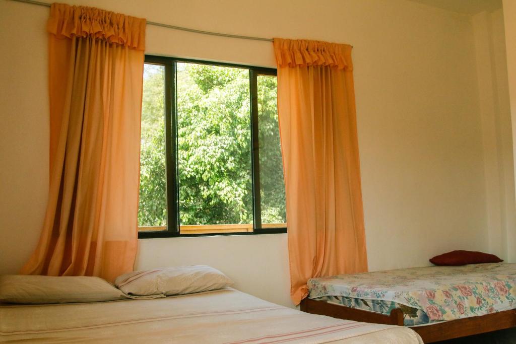 曼克拉Hospedaje Costa Norte的一间卧室设有两张床和大窗户