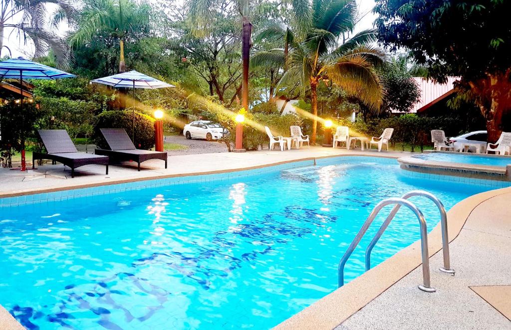 奥南海滩Mild Garden View Resort的度假村内带椅子和遮阳伞的游泳池