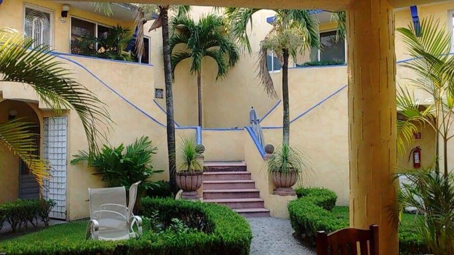 特米斯科HOTEL POSADA MONTSERRAT的棕榈树和楼梯前的房屋