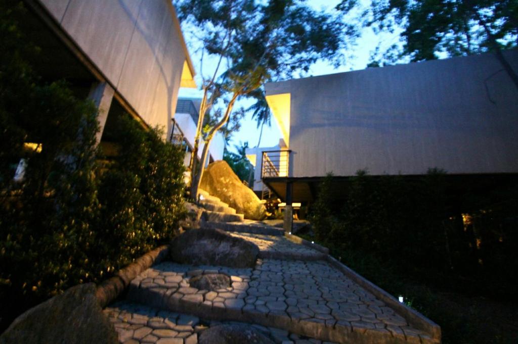 涛岛Matina Mountain Resort的夜间在建筑物前的石头走道