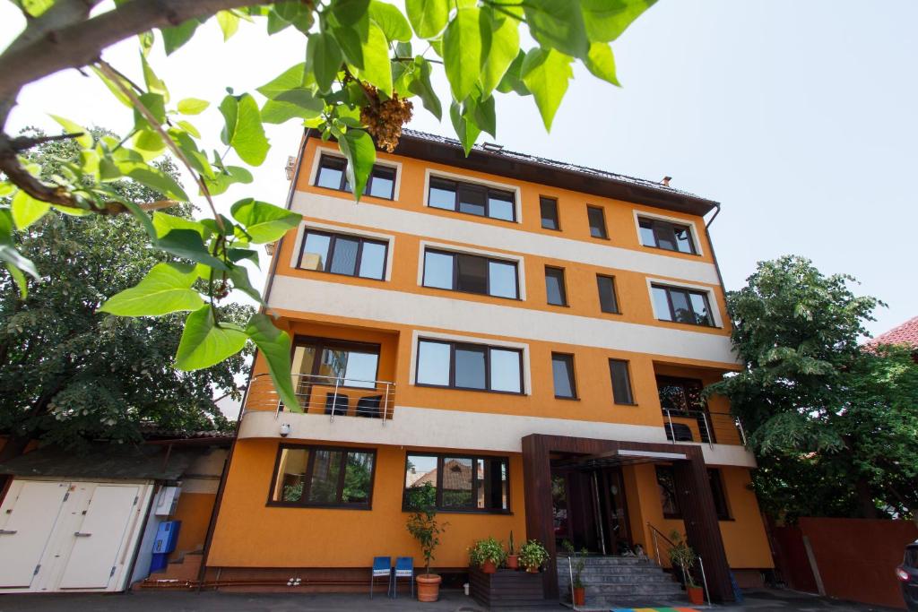 塔古玖安娜酒店的一座橙色和白色的建筑,设有窗户