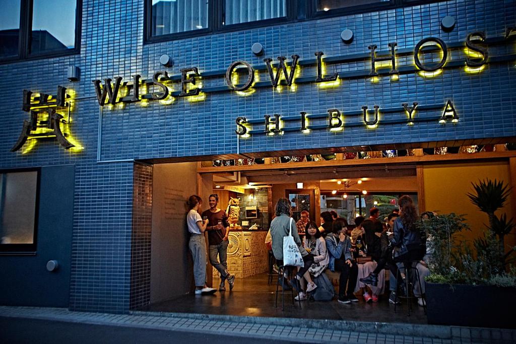 东京涩谷智慧猫头鹰旅舍的一群人站在商店外面