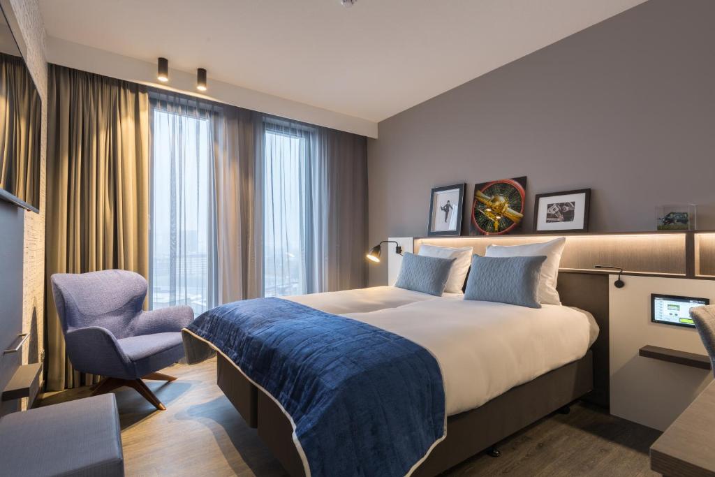 阿姆斯特丹Postillion Hotel Amsterdam的酒店客房带一张大床和一把椅子