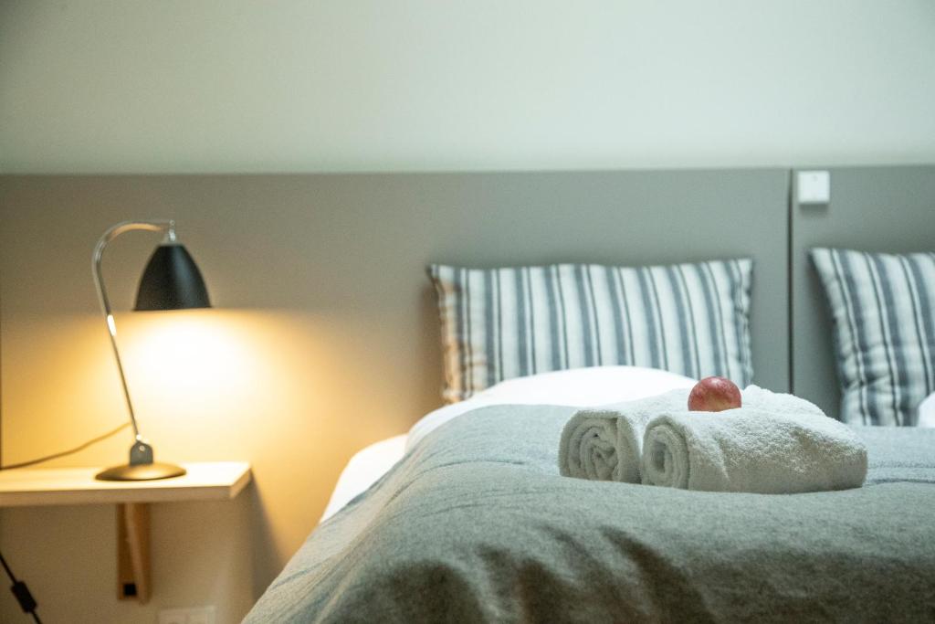 Sakskøbing萨克约滨酒店的一间卧室配有带毛巾和台灯的床