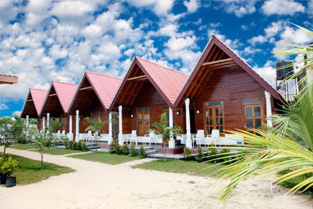 亭可马里Elegant Green Beach Resort的海滩上一座红色屋顶的房子