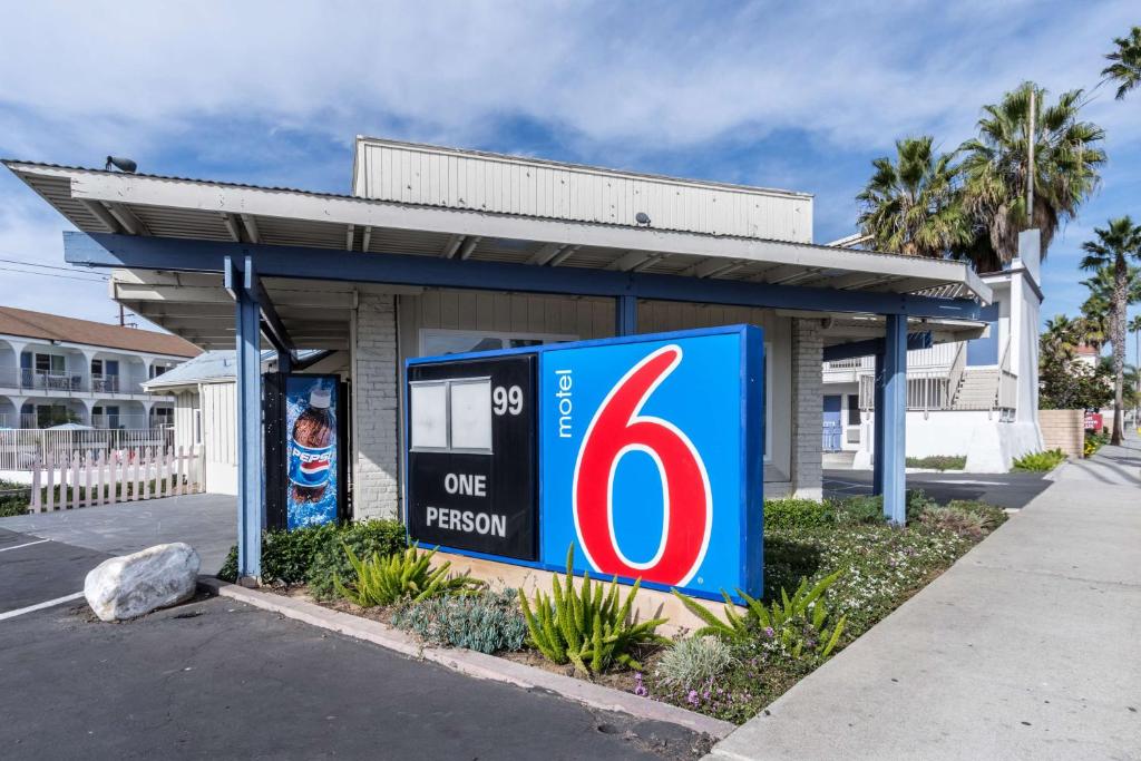 奥欣赛德Motel 6-Oceanside, CA, Marina的前面有一个人签名的加油站