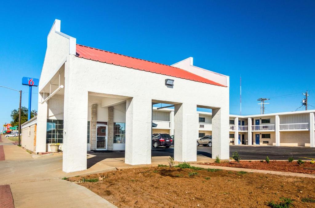 柴尔德里斯Motel 6-Childress, TX的一座大型白色建筑,设有停车场