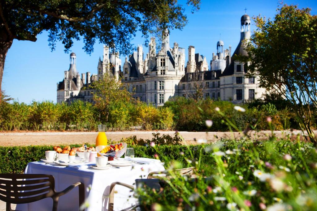 尚博尔查博德世界小型豪华酒店的城堡前的餐桌上放着食物