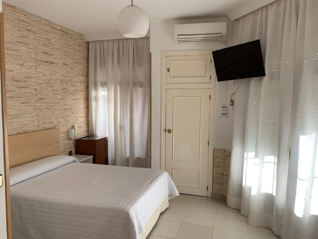 瓦尔德莫罗塞万堤斯旅馆的一间卧室配有一张床和一台平面电视