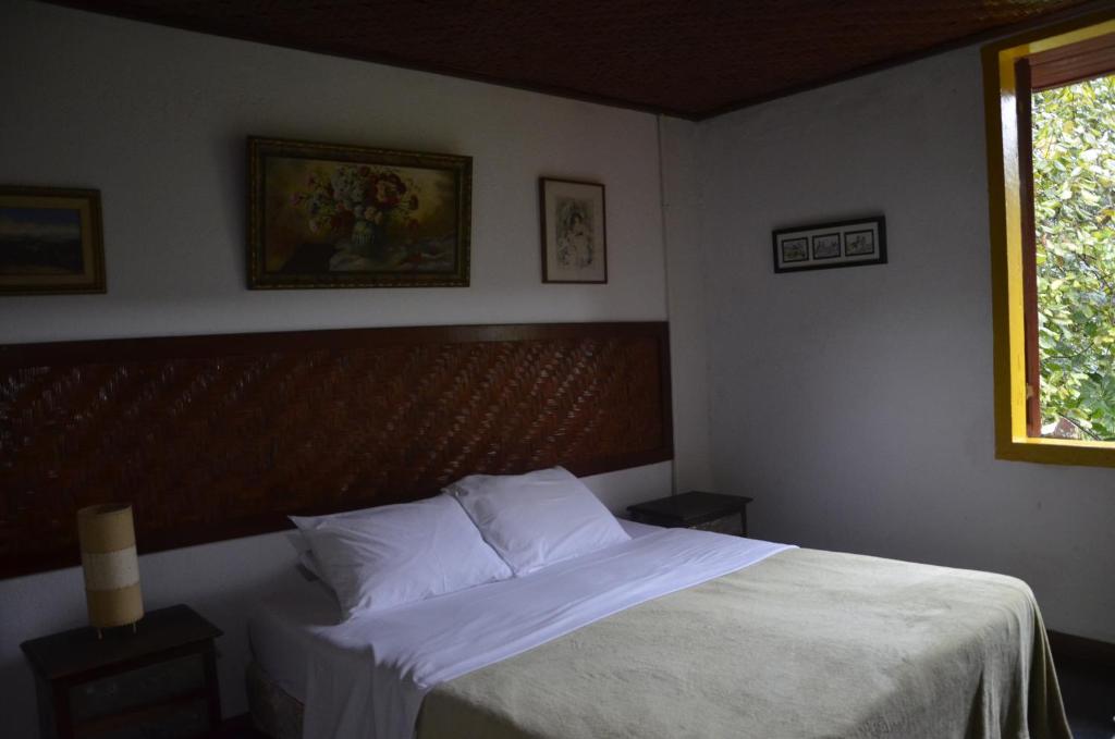马里亚纳Pouso da Passagem B&B的一间卧室配有一张带白色床单的床和一扇窗户。