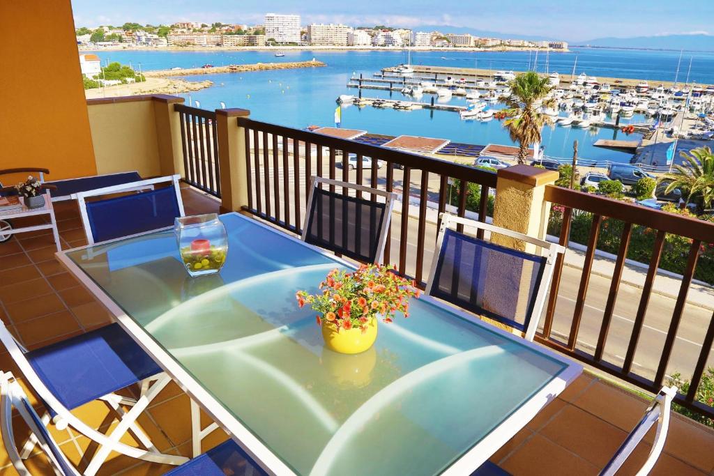 莱斯卡拉Apartment Colette的阳台配有桌子,享有海港景色