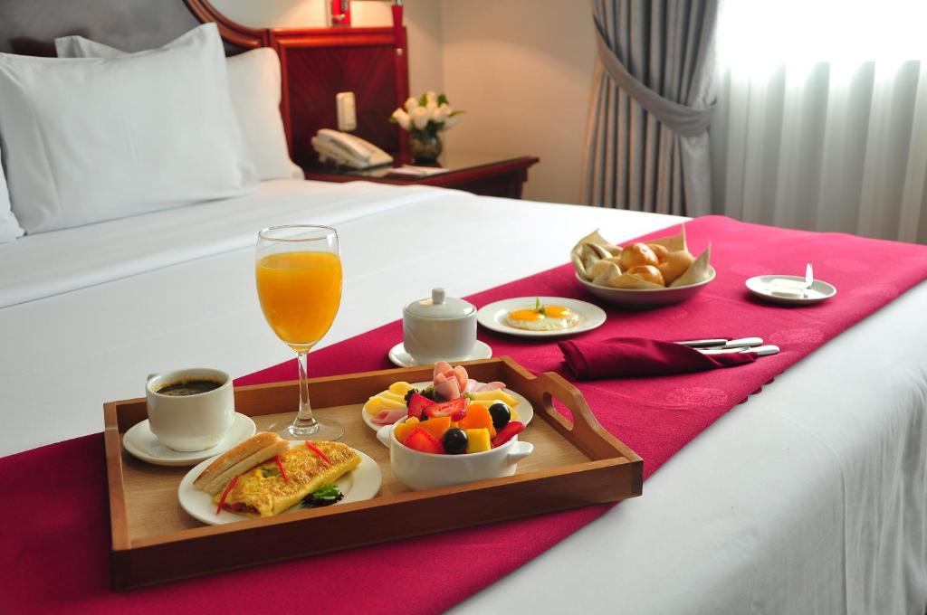 利马Kingdom Hotel的床上的食品和饮料托盘