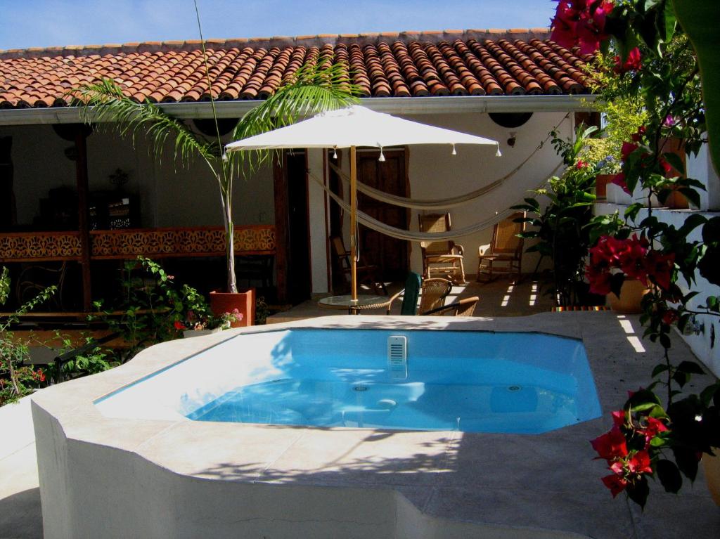 亨达卡萨布乐普可酒店的一座房子旁带遮阳伞的游泳池