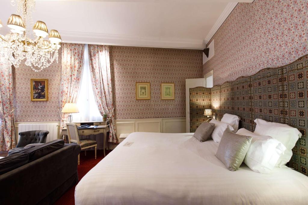 沙特尔Hotel & Spa Le Grand Monarque, BW Premier Collection的卧室配有一张白色大床和一张书桌