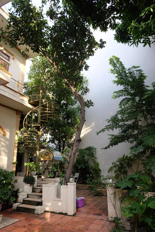 芽庄Moon house tropical garden - Valentine的一座有楼梯的建筑,前面有一棵树