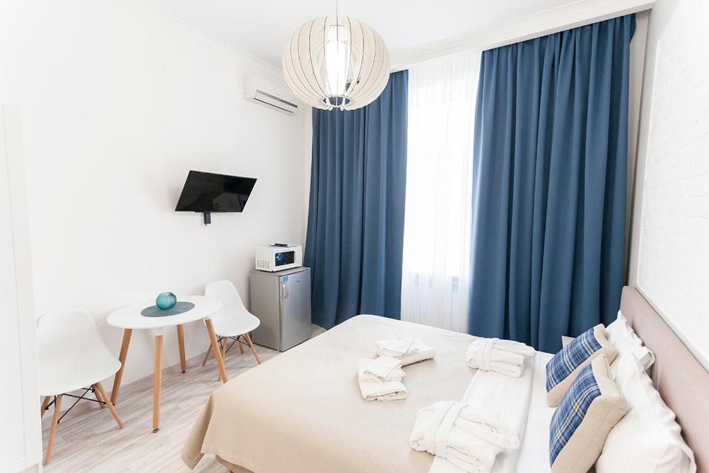 哈尔科夫Kharkov & Apartments in the city center的一间卧室配有一张带蓝色窗帘的床和一张桌子