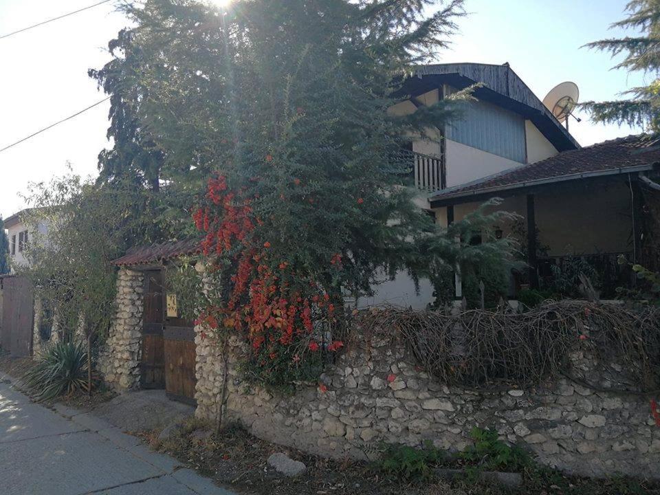 卡瓦达尔奇HOSTEL EMI的一座石墙房子和一棵红花树