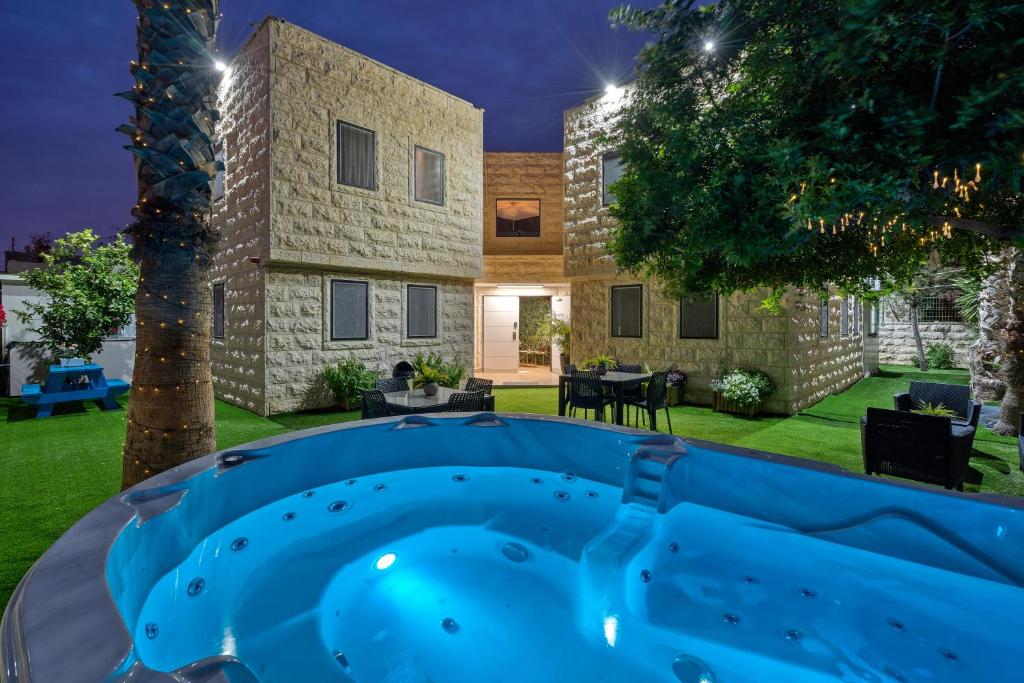贝尔谢巴מלון לה פינקה - מלון סוויטות יוקרתי的建筑前带热水浴池的后院