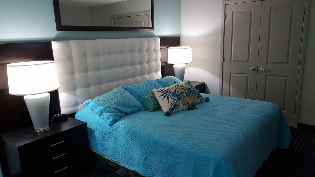 默特尔比奇15th Floor Ocean Front的一间卧室配有一张带蓝色床单的床和两盏灯。