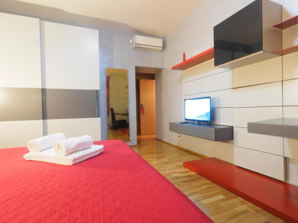 罗马圣彼得豪华公寓的一间设有红色床的客房,墙上配有电视