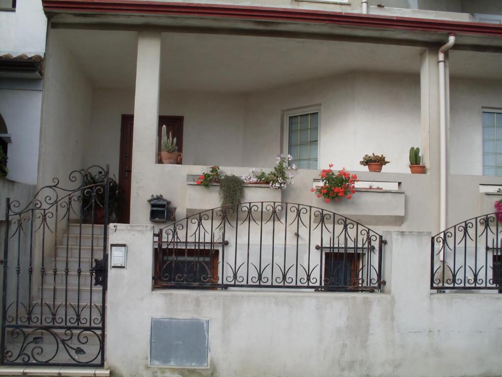 奥列纳Affittacamere Peonia的阳台上种植了盆栽的白色房子