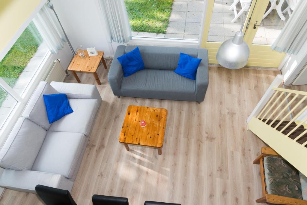 布雷斯肯斯Hello Zeeland - Vakantiehuis Duinroos 167的客厅享有高空美景,配有沙发和蓝色枕头