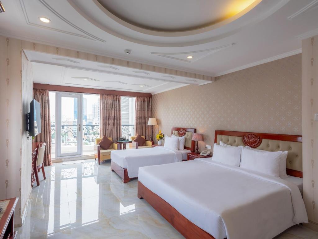 胡志明市Bon Ami Hotel - Thiên Xuân Hotel的酒店客房设有两张床和大窗户。