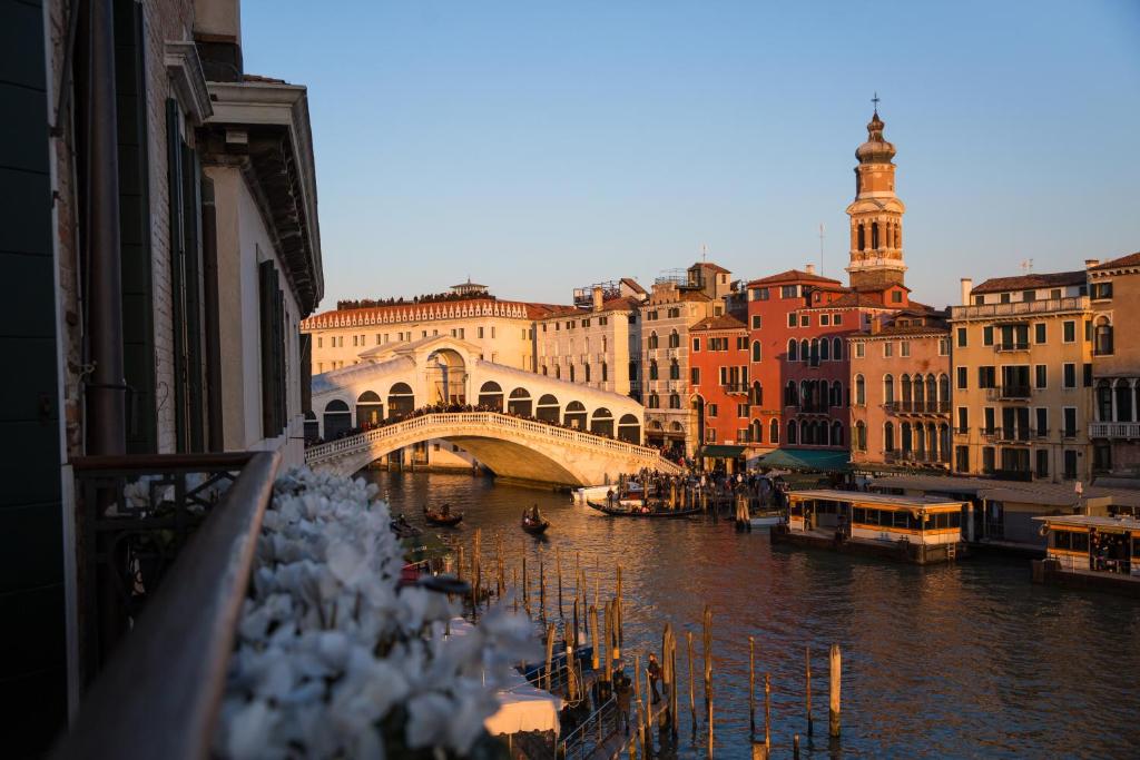 威尼斯Riva del Vin BOUTIQUE HOTEL的一座建有建筑物的城市里河流上的桥梁