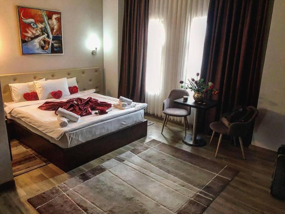 斯科普里AEN Hotel-Old City的酒店客房带一张床、一张桌子和椅子