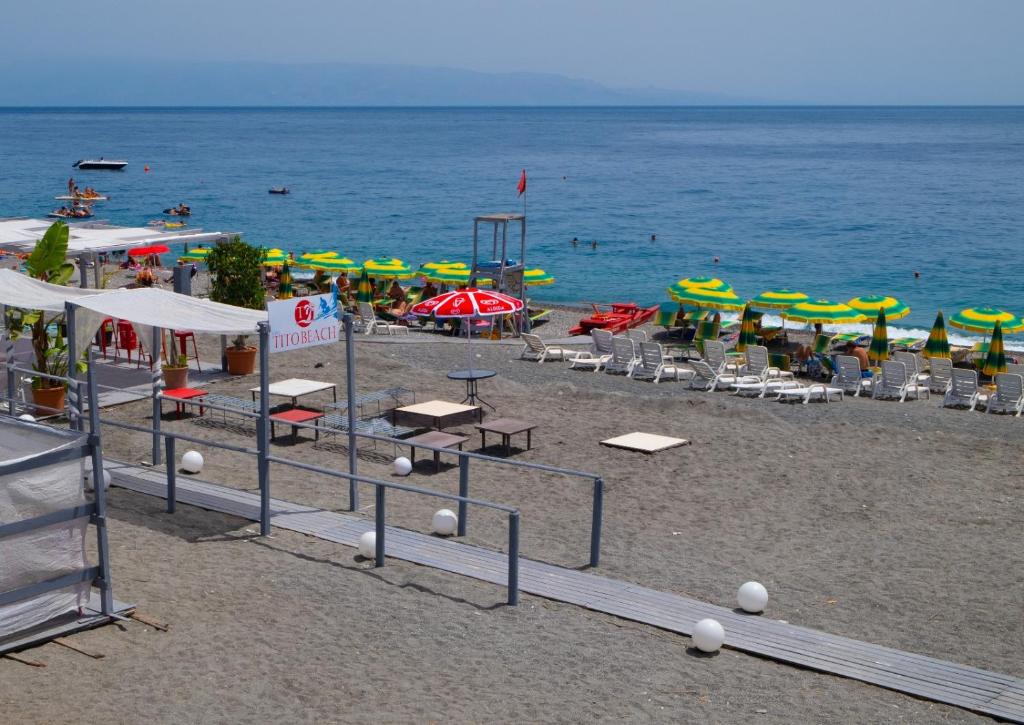 洛卡卢美拉Casa del Melograno 40的海滩上设有椅子和遮阳伞,水面