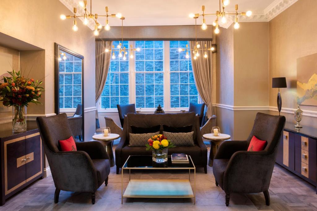 爱丁堡爱丁堡辉盛阁国际公寓的客厅配有椅子、沙发和窗户