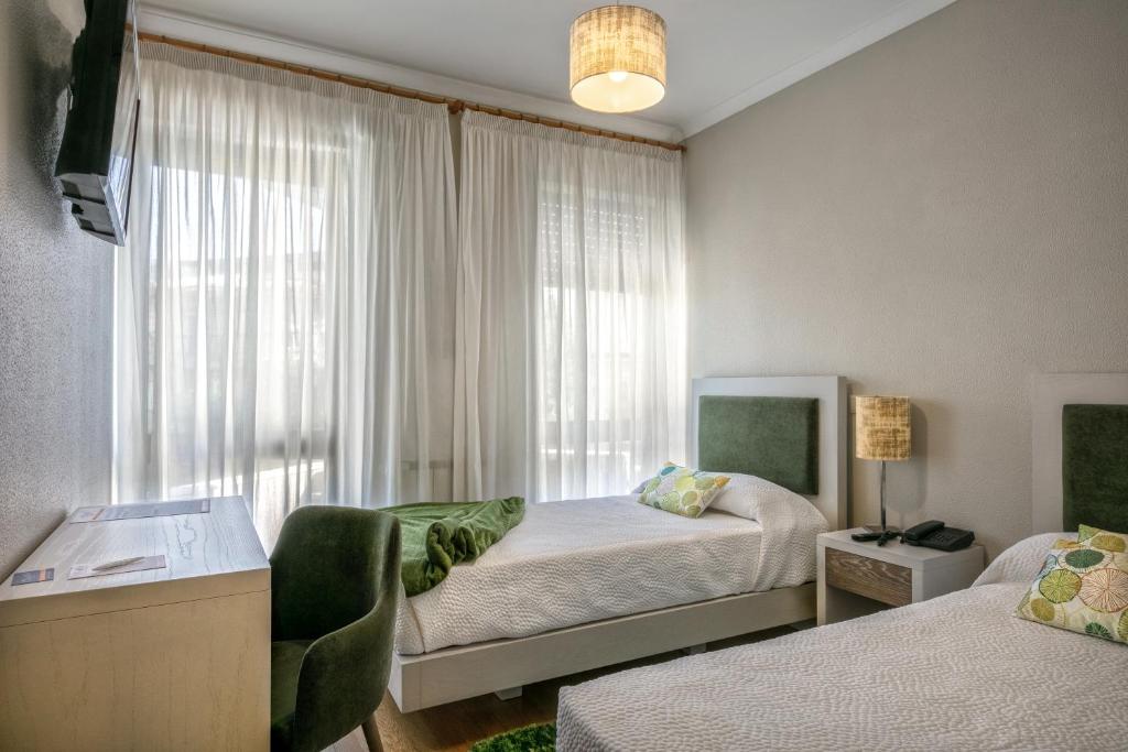 维拉·雷阿尔克莱斯科旅馆的一间卧室设有两张床和窗户。