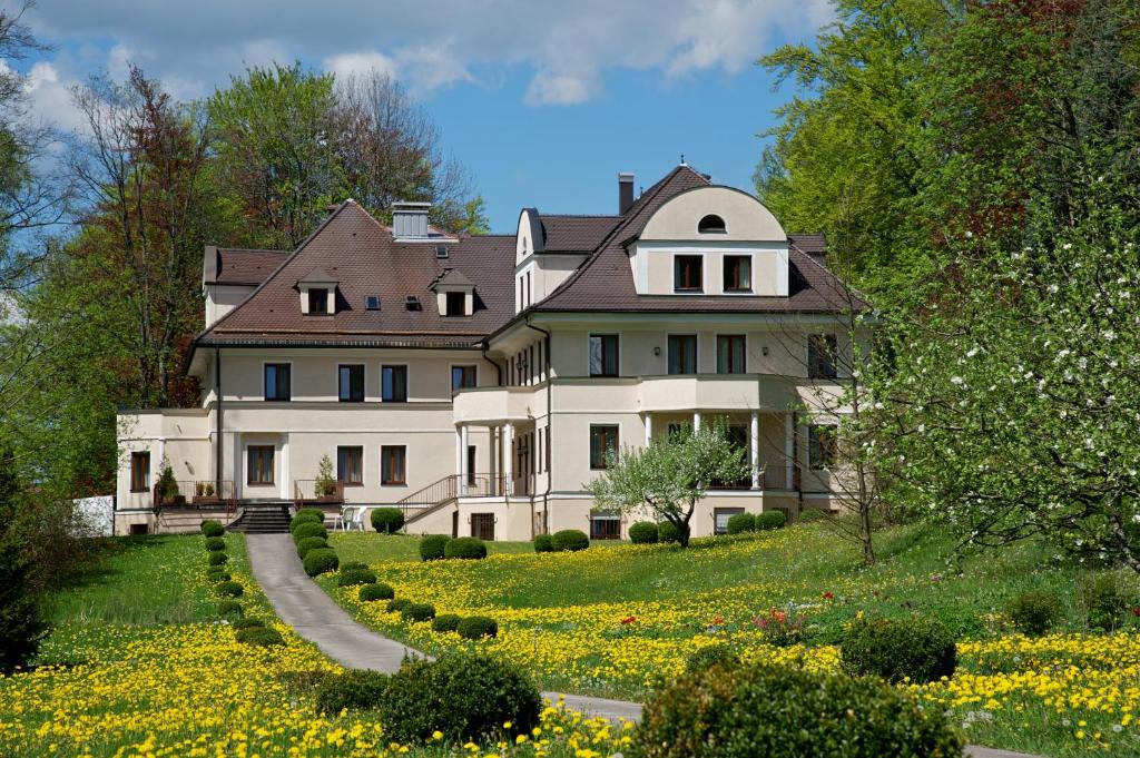 福森hideauts hotels Der Rosengarten的一座花丛中的山丘上白色大房子