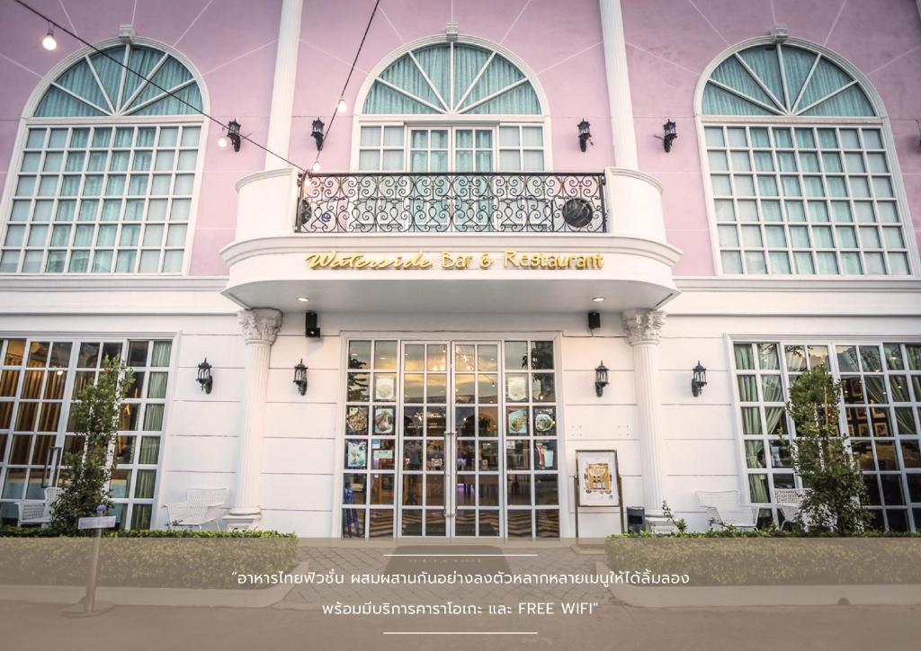 Ban Bang Kho维斯塔格酒店的粉红色和白色的建筑,设有大门