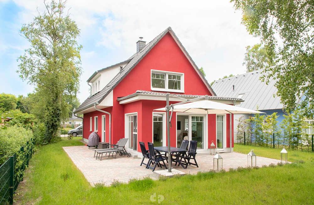 奥茨塞巴德·迪尔哈根Ferienhaus ELSA Kinder erst ab 12的院子里的红色房子,配有桌椅