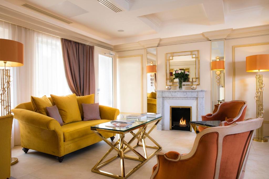 巴黎瑞典圣日耳曼酒店的客厅设有黄色沙发和壁炉