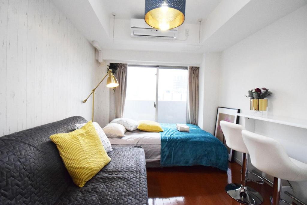 东京Square Shibuya 909的一间卧室配有一张床、一张沙发和一个窗口
