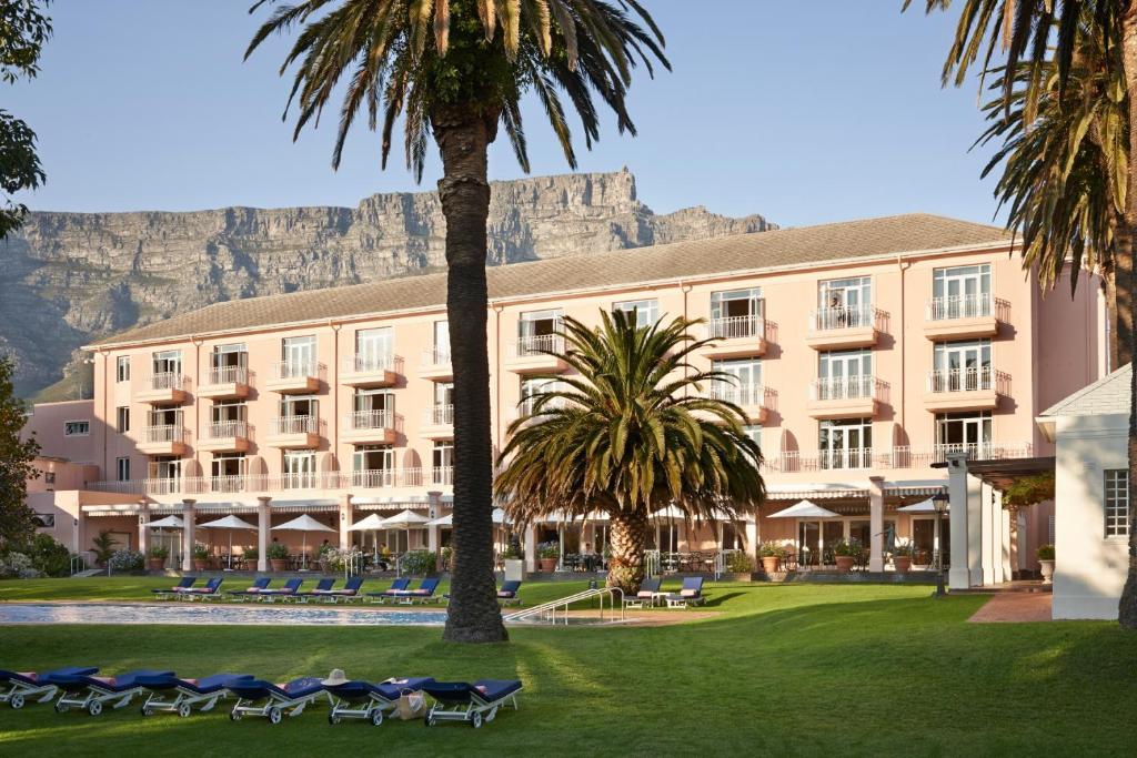 开普敦Mount Nelson, A Belmond Hotel, Cape Town的棕榈树和山脉环绕的酒店